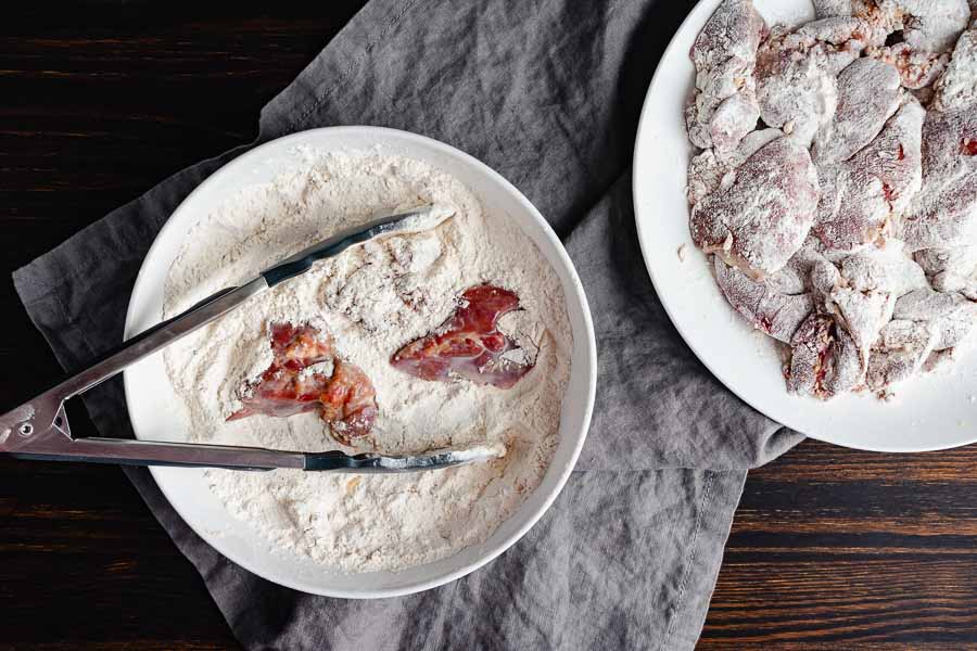 Dredging the milk-soaked chicken livers in seasoned flour