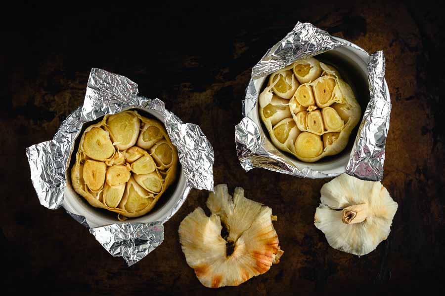 Roasted garlic cloves in foil-covered ramekins