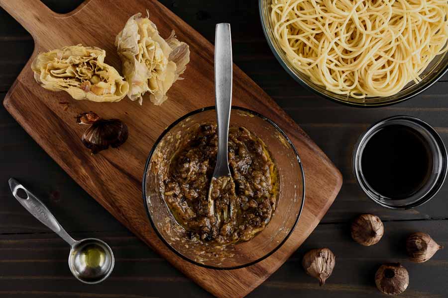 Mashing orated garlic and black garlic with a fork