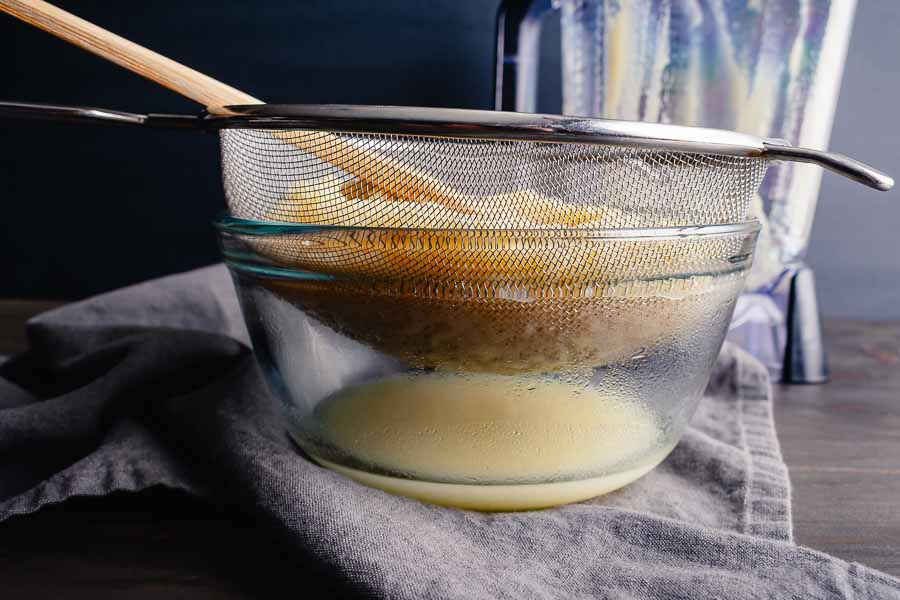 Straining excess liquid from white pumpkin puree