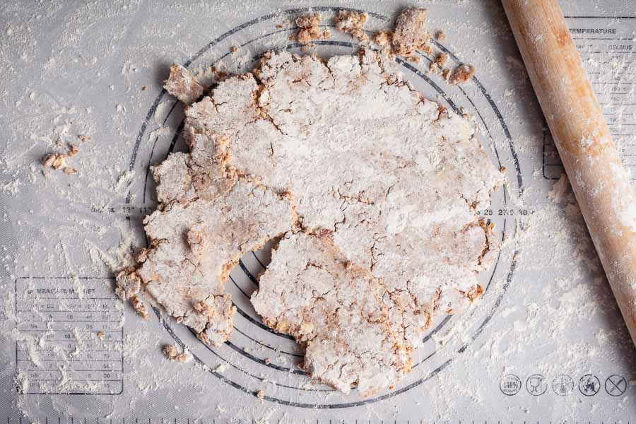 Crumbled pie crust dough on a silicone mat